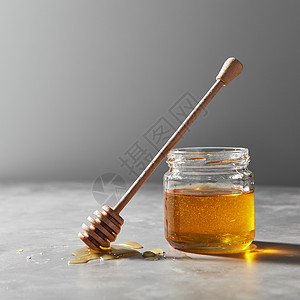 木勺滩糖浆个璃瓶与新鲜的天然机蜂蜜灰色的混凝土背景上,放置文字犹太新假期滩新鲜的花蜜桌子上,璃壶背景图片