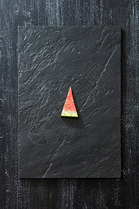 三角形板多汁的三角形西瓜片石板板上的黑色混凝土背景与的文本夏日甜点的风景片新鲜的西瓜黑色的石板上,黑色的混凝土背景