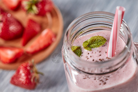 自制草莓奶昔与CHIA种子绿色薄荷叶个罐子与个小管个木制的背景机维生素甜点的风景机牛奶草莓冰沙背景图片