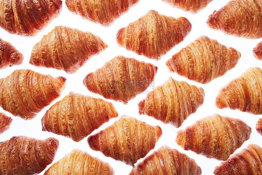 白色背景上的新鲜自制法国牛角包菱形角线图案欧式早餐的白色背景上新鲜烤牛角包的图案图片