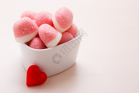 甜食糖粉红色果冻棉花糖白色碗木桌上装饰红色的心爱符号背景图片