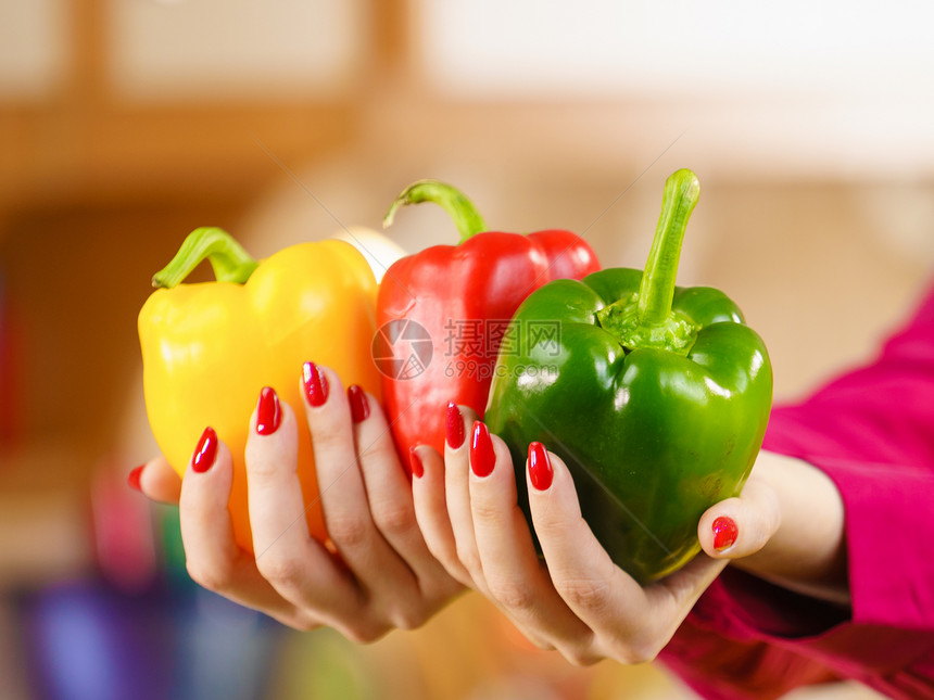 女人手钟椒美味健康的减肥蔬菜,呈现三种颜色的饮食食物着辣椒辣椒的女人图片