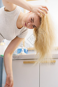 金发女人浴室油腻的油头发的问题女露出头皮,挠自己,脱发,头皮屑问题女金发问题背景图片