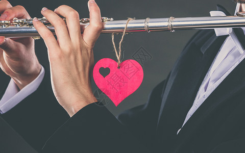 情人节爱情旋律长笛音乐演奏男子流感音乐家表演者男手用乐器红心,特写长笛心脏的男流感医生爱的旋律背景图片