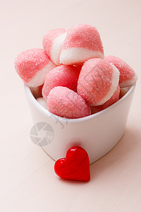 甜食糖粉红色果冻棉花糖白色碗木桌上装饰红色的心爱符号背景图片