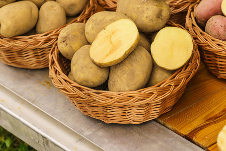 把许多土豆放柳条篮子里素食健康食品柳条篮子里的土豆高清图片