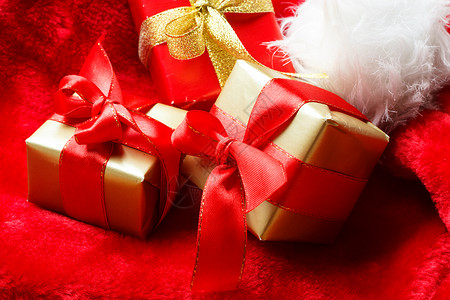 假期,现,诞节的红色背景上带礼物的小盒子绑着蝴蝶结图片