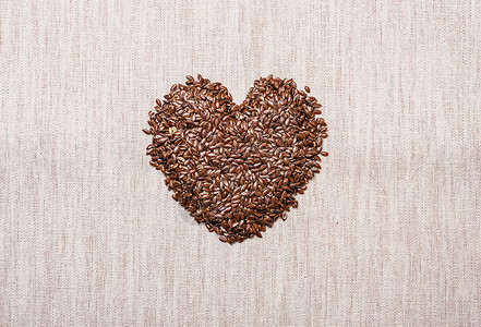 饮食保健健康食品生亚麻籽亚麻籽心形状的麻袋麻布背景背景图片