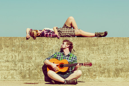 轻人海边约会的时候,户外给女朋友弹吉他高清图片