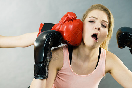 拳击比赛中,戴拳击手套的女人被打,下巴受伤图片