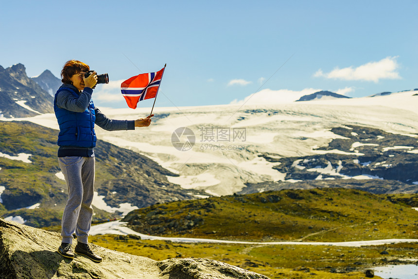 游客妇女欣赏山脉景观,手持挪威照片相机旅游景区路线55索涅夫杰莱特,挪威挪威山区带相机的游客图片