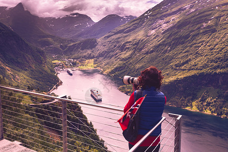 摄影欣赏课件旅游假日图片旅游奥恩斯文根鹰路角度欣赏峡湾景观的女游客,用相机拍照,挪威游客拍摄峡湾景观,挪威背景