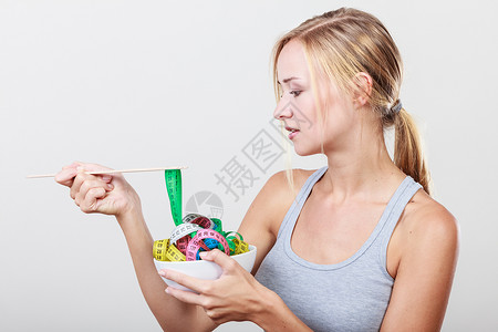 饮食,健康饮食,减肥苗条的身体观念适合健身女孩碗与许多彩色测量磁带图片