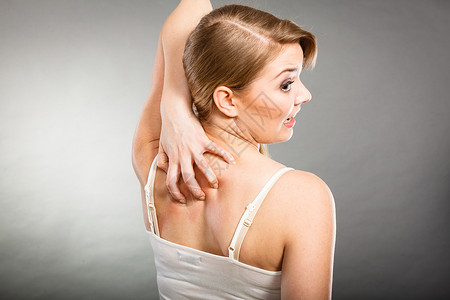 健康问题,皮肤病轻的女人用过敏皮疹挠痒的背部女人用过敏皮疹抓痒背部背景