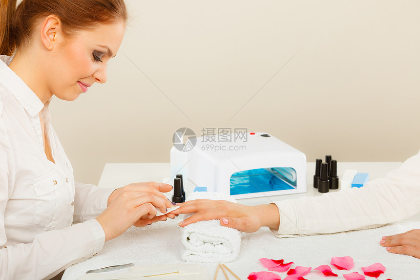 女人用手毛巾,准备凝胶混合指甲,用指甲油除指甲上的灰尘油美容健康水疗护理理念女用指甲油除剂指甲图片