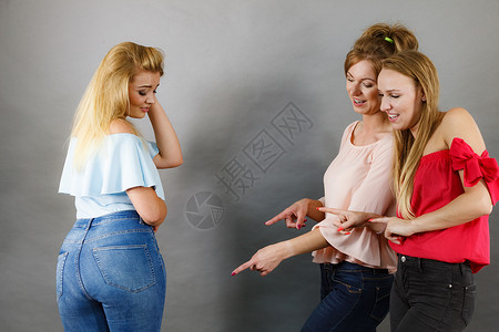 女人被两个女朋友欺负,八卦她的体型友谊竞争嫉妒问题女人谈论朋友的体型争论高清图片素材