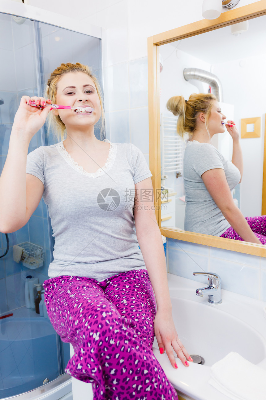 女人刷牙特写趣的金发女孩带着牙刷浴室口腔卫生女人浴室刷牙图片
