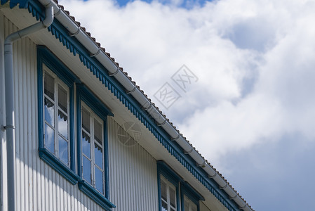 老式的白色木材制成的房子,蓝色的窗户与天空与云彩建筑细节用蓝色窗户白宫图片