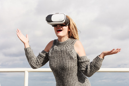 轻的女人外测试VR眼镜女春天的天气里戴着虚拟现实耳机,穿VR的女人外图片