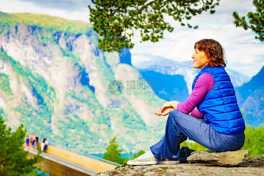 游客妇女越过Stestein瞭望台,看着挪威峡湾山脉的景色徒步旅行,旅途放松旅游景区路线极光游客享受山脉峡湾景图片