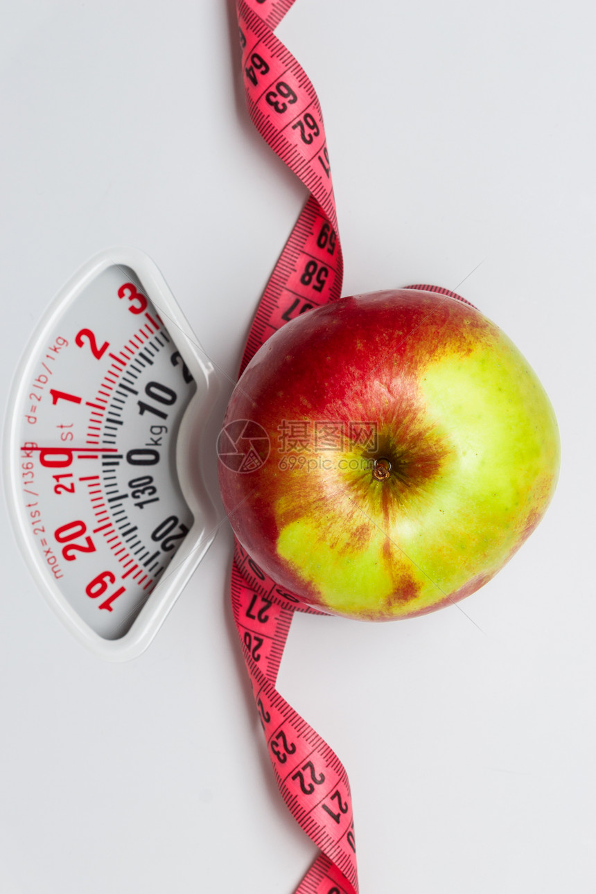 节食健康饮食减肥理念特写苹果与测量磁带白色重量秤图片