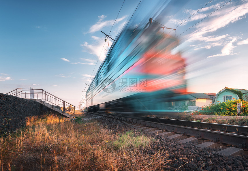 夏季傍晚铁路上运行的高速客运列车日落时移动模糊的现代通勤列车工业景观与火车站蓝天运输旅行日落时铁路上运图片