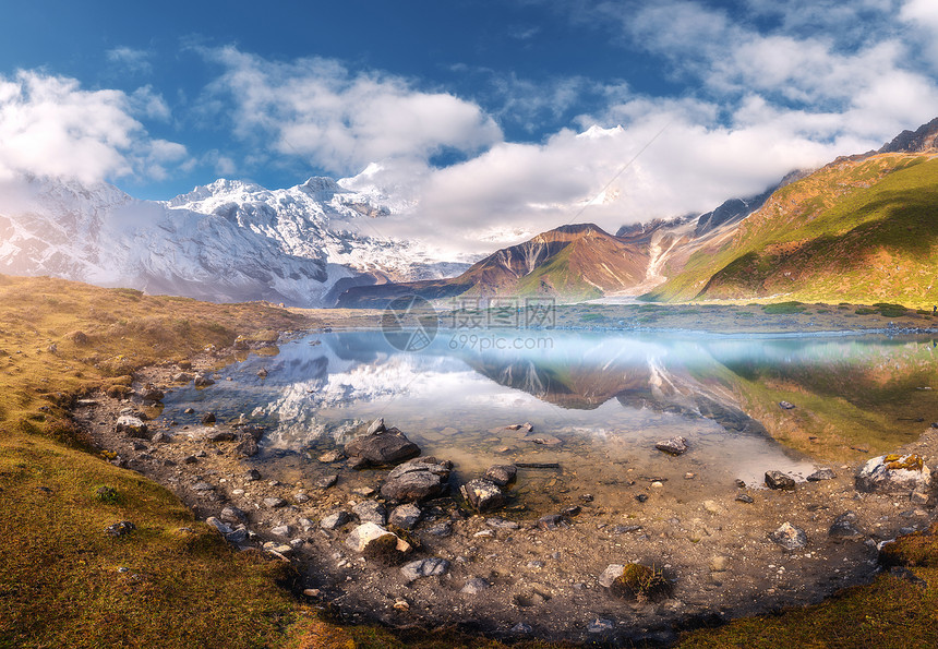秋天日出时,山谷中雾的美丽湖泊风景雪马纳斯鲁山,石头,黄草,青山,蓝天白云,倒影尼泊尔的水中自然图片