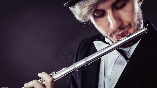 古典音乐,激情爱好穿着优雅的音乐家人长笛工作室拍摄深灰色背景穿着优雅的男音乐家长笛背景图片