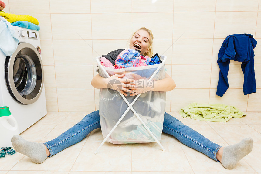 快乐趣的女人浴室里着篮子脏衣服洗衣家务女人带着篮子脏衣服洗衣图片