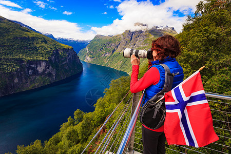 旅游假日图片旅游奥恩斯文根鹰路角度欣赏峡湾景观的女游客,用相机拍照,挪威游客拍摄峡湾景观,挪威背景图片