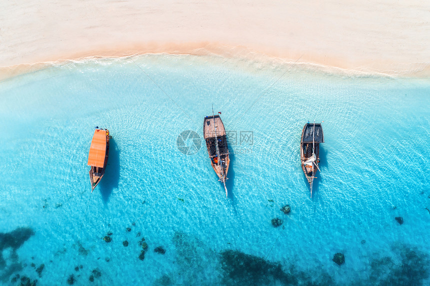 夏天的日落时,清澈的蓝色水中俯瞰渔船桑给巴尔的小船游艇沙滩的无人驾驶飞机上俯瞰旅行热带海景与帆船,海洋图片