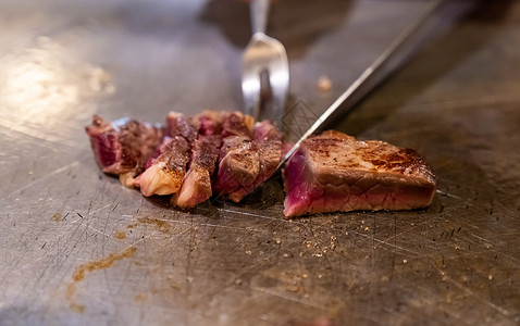 锅里铁板烧用刮刀刀煮锅上烹饪牛肉铁板烧食谱日本烤牛肉背景