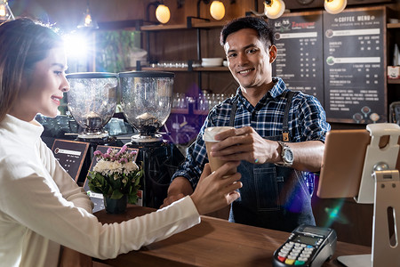 外卖酒吧素材亚洲咖啡师的肖像,走咖啡杯,并咖啡馆为顾客服务背景