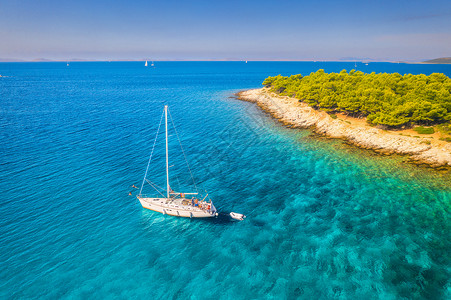 夏季在Croati的阳光明媚天气中海美丽的帆船和小岛风景绿色蓝水树沙滩游艇的顶层风景背景图片