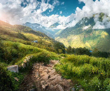 山谷的美丽石头足迹在春日落时山谷的春日底地貌与石阶绿草山丘与森林蓝云天空与夜晚的阳光惊人自然旅行背景图片