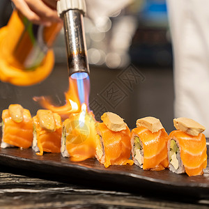 烹饪大厨三文鱼鹅肝卷聚日本烹饪食品使用燃气炉火炬背景图片
