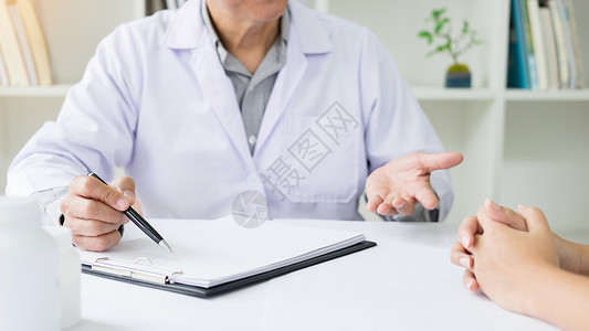 病人在一次咨询中起讨论文书工作时故意倾听一名男医生解释病人的症状或问一个题背景图片