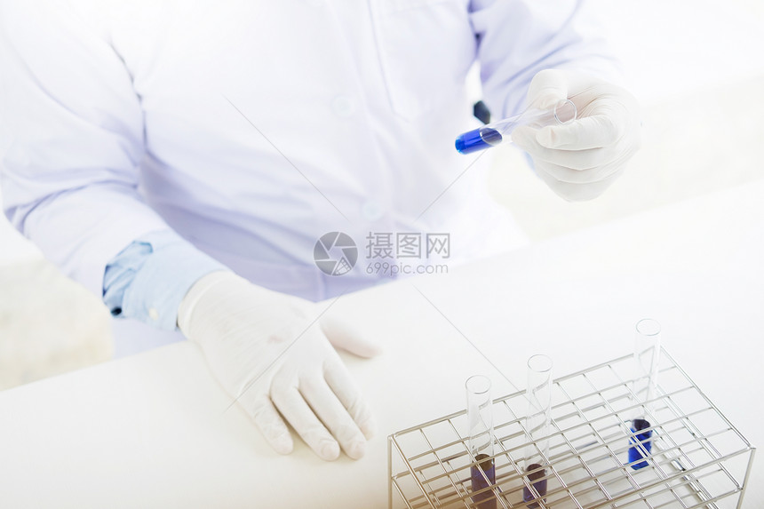 在实验室工作的亚洲科学研究员持有测试管并使用化学制造进行液溶分析图片