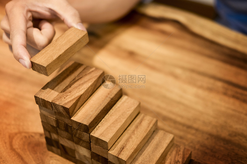 人手把木制块堆叠以促进发展作为阶梯增长概念和成功计划图片
