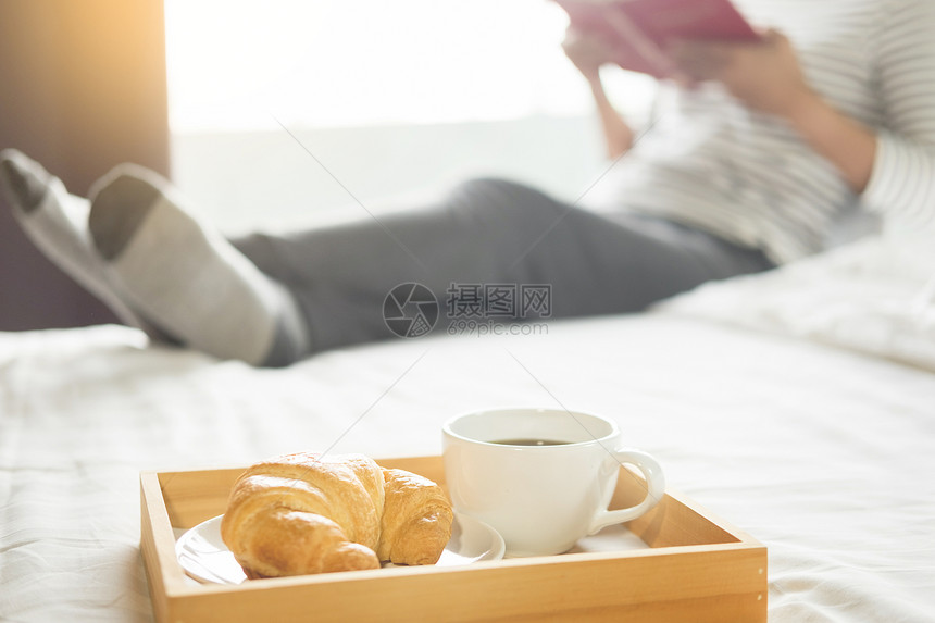妇女早上在床上看书喝咖啡图片
