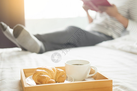 妇女早上在床上看书喝咖啡图片