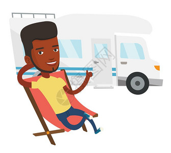 男青年在汽车前坐在折叠椅上图片