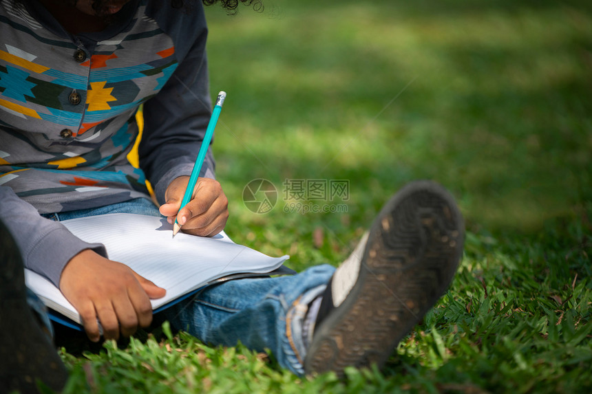在草地上写作业的小女孩图片