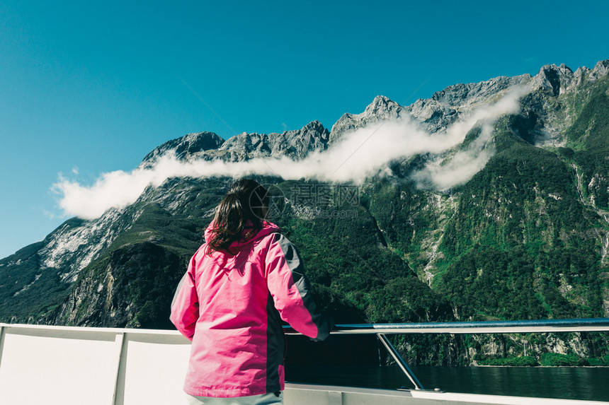 在甲板上观看新西兰南部岛屿风景的女旅行者图片