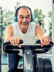 在健身房骑运动单车的老年男人背景图片