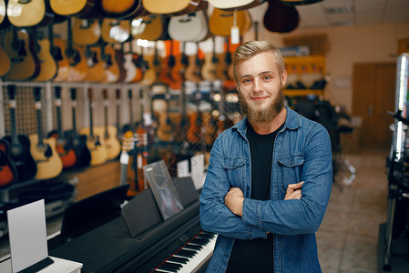 青年男子在吉他音乐店的购买设备卖方高清图片素材