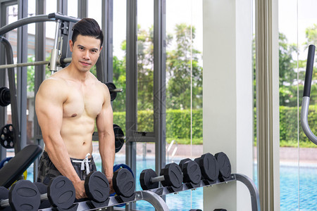 在健身房用哑铃锻炼身体的男子图片