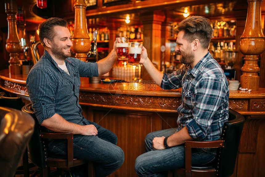 两个男人在酒吧柜台喝啤酒图片