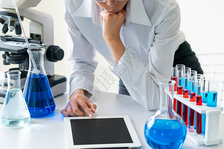 在实验室工作并检查试管生物化学样本的女科家技术研究和发展概念背景图片