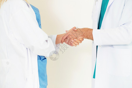 gp医生和白背景的外科医生握手图片